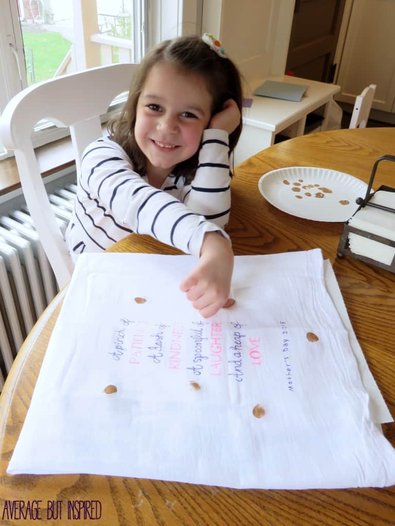 Turn kids' thumbprints into cookies on a cute tea towel. It's the perfect gift for a mom or grandma who bakes! Plus, the free downloadable quote can be used as a template for your own tea towel!