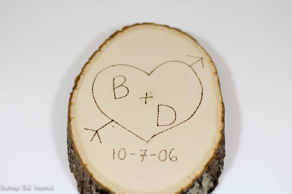 Using a wood burning tool on a craft wood slice to make a DIY Valentine's Day gift.