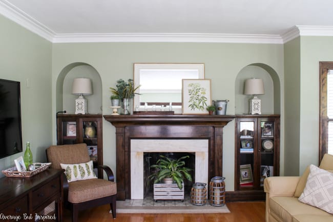 Check out this post to see beautiful summer mantel decorating ideas in shades of green and pulling elements from nature. Botanical prints, galvanized metal buckets, and a glass vase collection are some of the elements included.