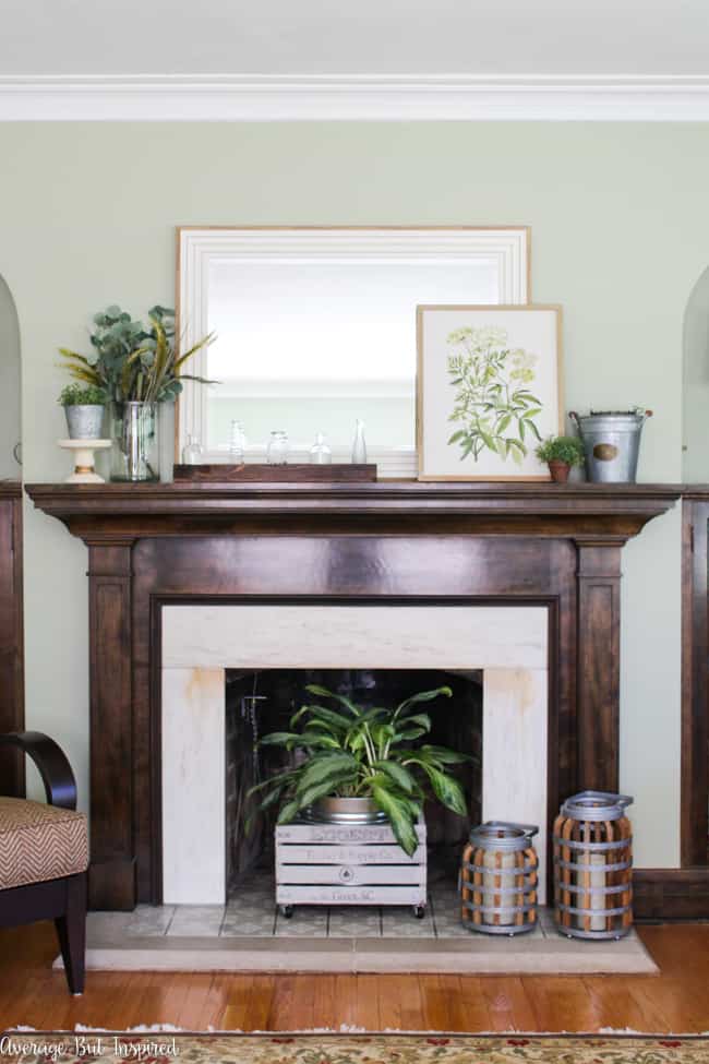 Check out this post to see beautiful summer mantel decorating ideas in shades of green and pulling elements from nature. Botanical prints, galvanized metal buckets, and a glass vase collection are some of the elements included.