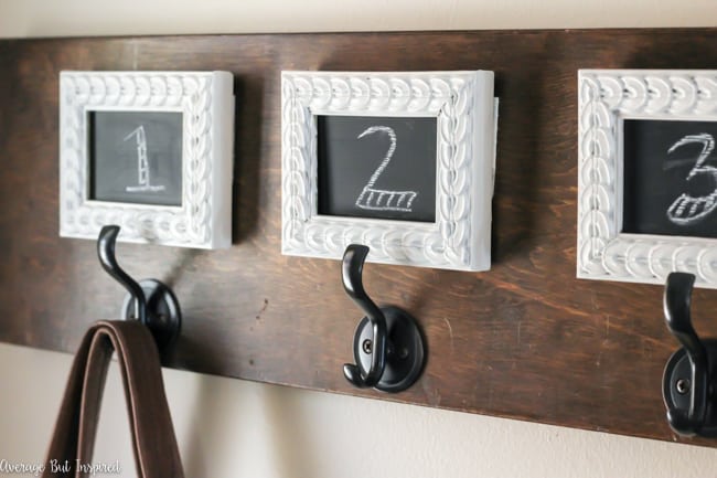 Love this small foyer decor! A pretty table, potted plant, and decorative accessories make it a functional and stylish space. The bench and wall hooks add to the functionality of this small entryway!