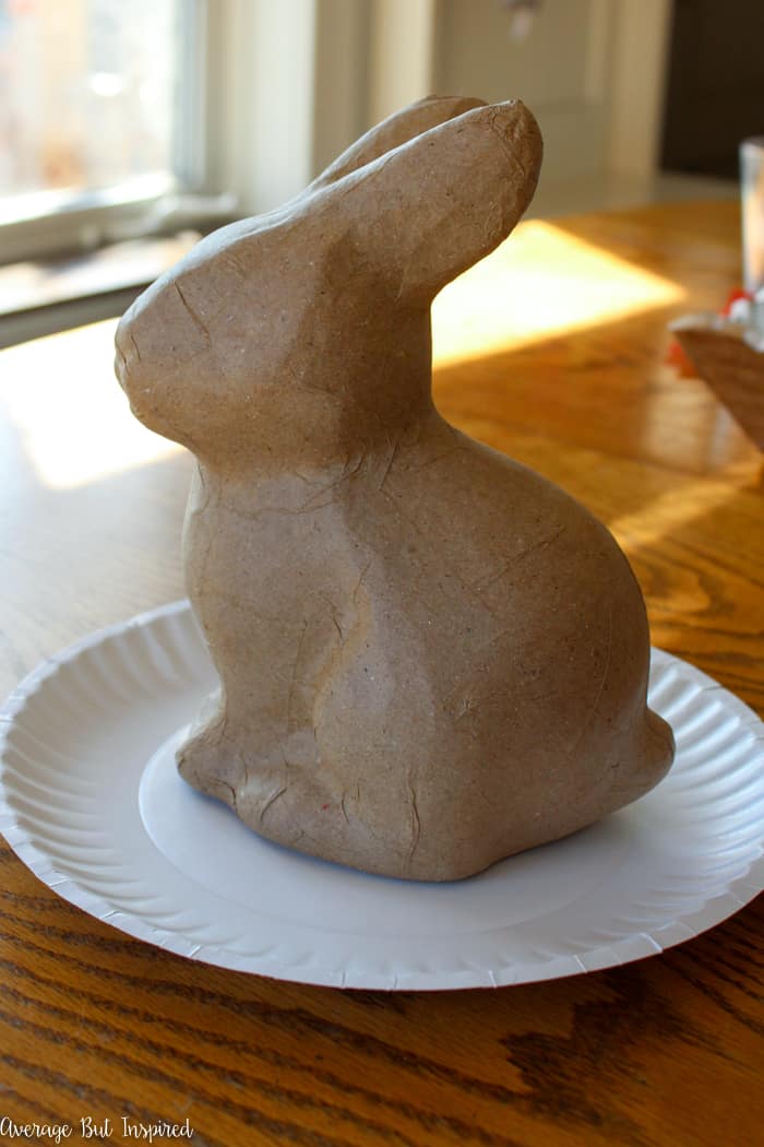 Transform an unfinished paper mache bunny into a charming and pretty vintage paper mache bunny with simple supplies like newspaper and paper flowers. This paper mache bunny will add such a pretty touch to your spring or Easter decor!
