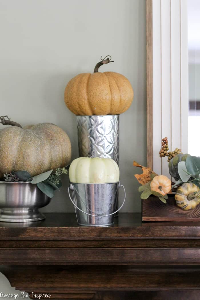 Beautiful! See how this blogger used inexpensive items like faux pumpkins, book pages, and acorns to create a pretty fall mantel in shades of green, orange, and white.