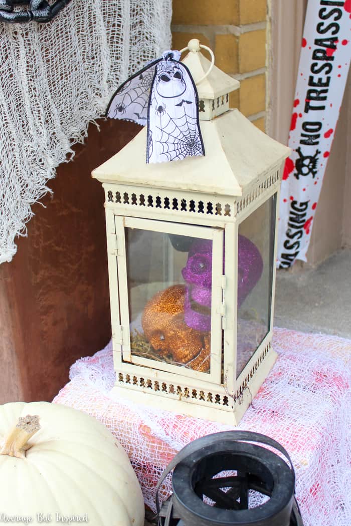Glittered skulls in an outdoor lantern are a fabulous way to decorate for Halloween! These dollar store Halloween porch decor ideas are not to be missed!
