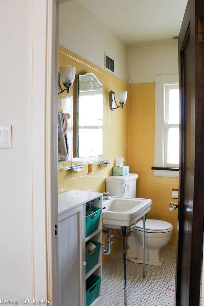 This vintage 1920s bathroom features bright yellow tile and original fixtures.