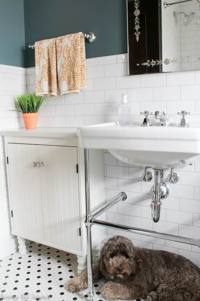 White subway tile, white and black hexagon mosaic floor tile, and a console sink with chrome legs make for a gorgeous 1920s inspired bathroom.