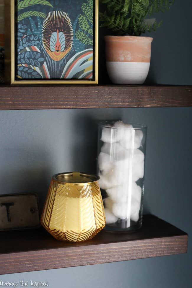 Floating shelves above the toilet are a place to display art and other decorative items, as well as functional items for the bathroom.