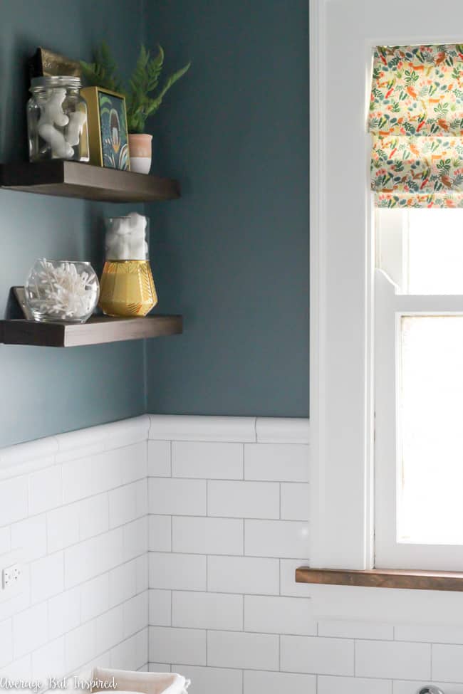 This bathroom features beautiful white subway tile with chair rail and light gray grout. Wall color is Charlotte Slate by Benjamin Moore.