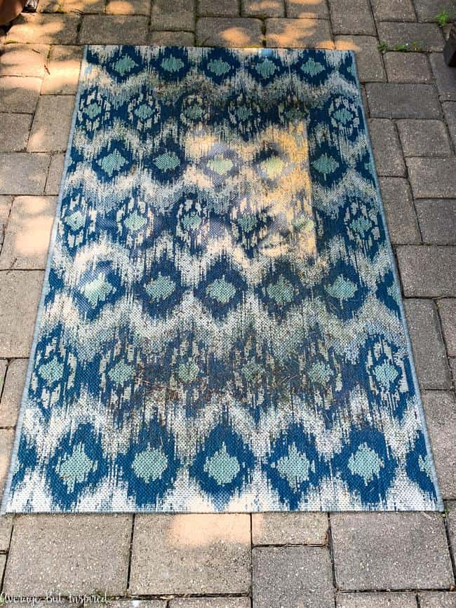 Gross! This nasty outdoor rug may seem impossible to clean, but this post will show you how to clean an outdoor rug and get it looking brand new!