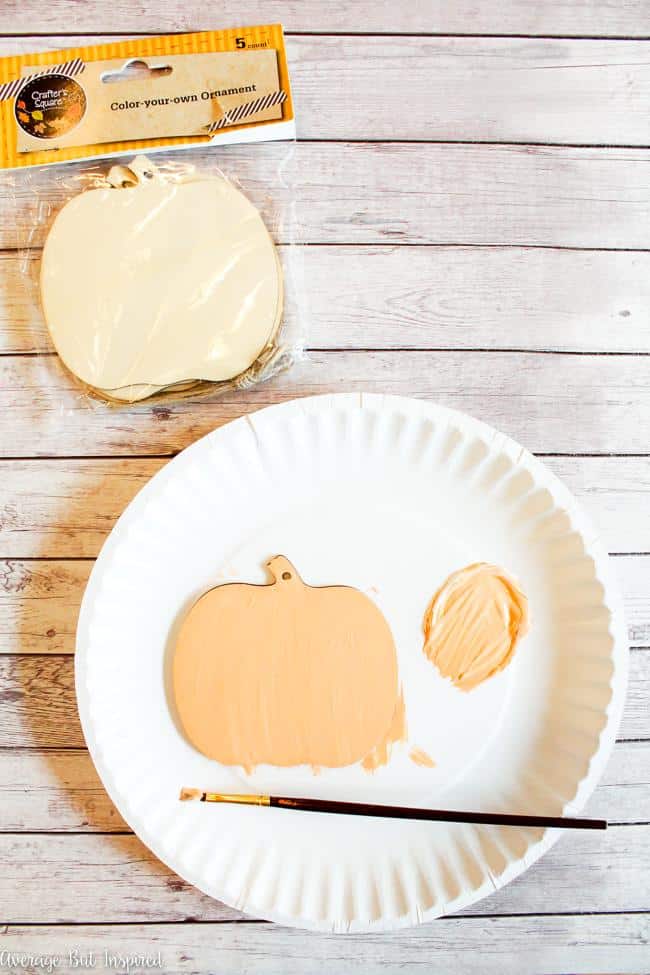 Paint plain Dollar Tree pumpkin ornaments to create a cute pumpkin sign for fall.