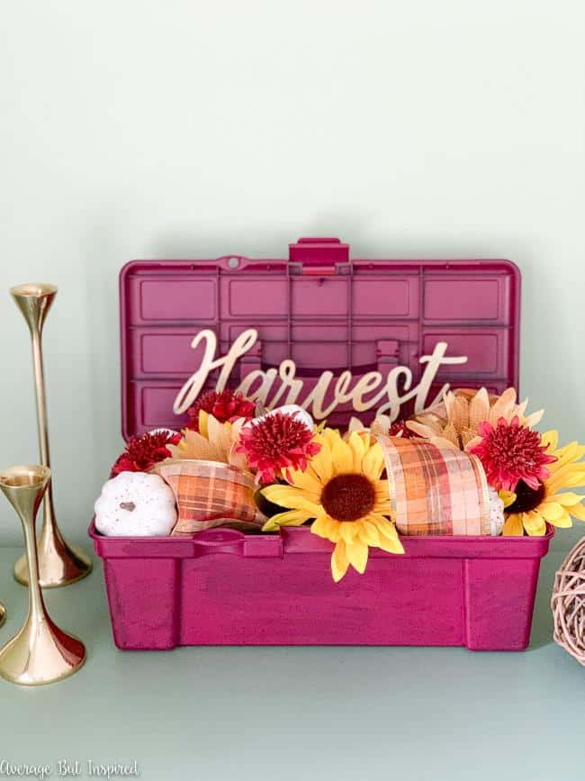 Love this pretty fall flower arrangement! See how she transformed a Dollar Tree toolbox and made it a beautiful fall planter!