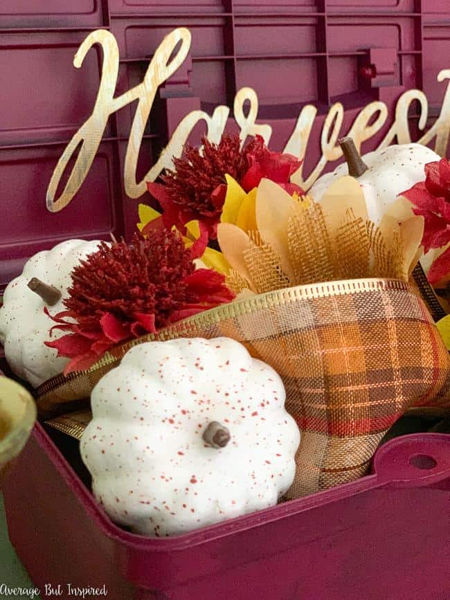 Faux pumpkins, plaid ribbon, and faux florals make a beautiful fall floral arrangement.