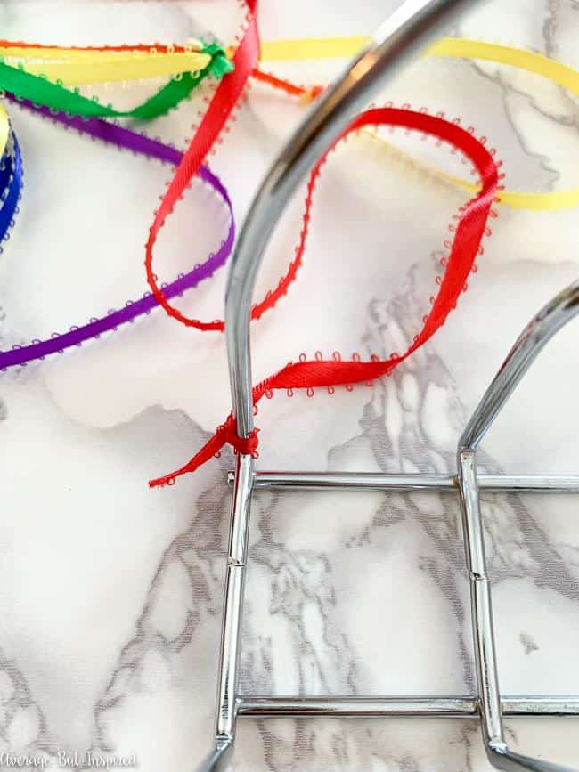 Wrap the ribbon around the napkin holder to create the DIY rainbow room decoration.