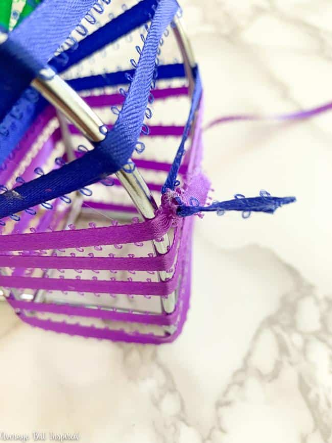 Make sure to add dots of hot glue to the ribbon as you wrap it around the metal napkin holder.