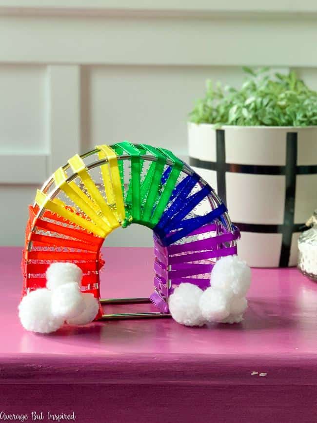 CUTE! See how she transformed a Dollar Tree napkin holder into darling DIY rainbow room decor! This rainbow decor looks super cute on a shelf or when displayed as part of a St. Patrick's Day celebration.