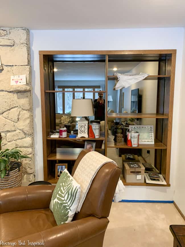 Before these dated 1970s mirrored built-in bookcases got a makeover, they were an eyesore with thin trim and mirrored backs!