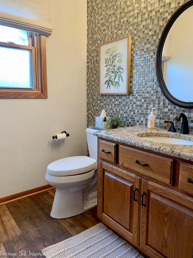 Before giving this powder room a makeover, it had orange oak cabinets, dated granite, and a crazy tile wall.