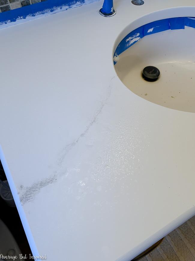 Adding gray veins to the painted countertop helps it look like marble.