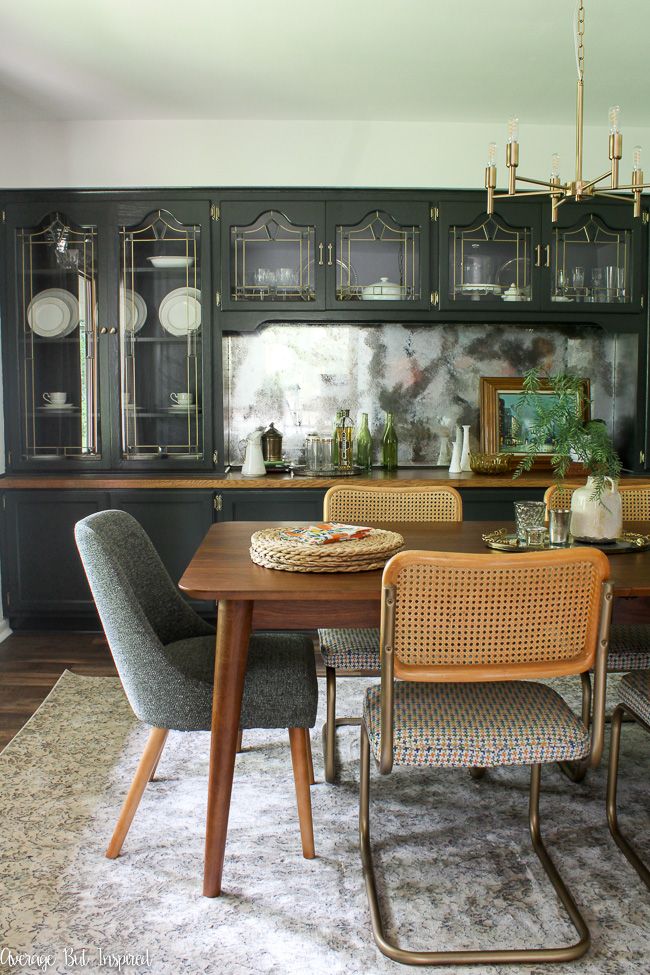 This modern vintage dining room makeover features a dark green built-in china cabinet, sleek mid-century modern furniture, and brass accents.