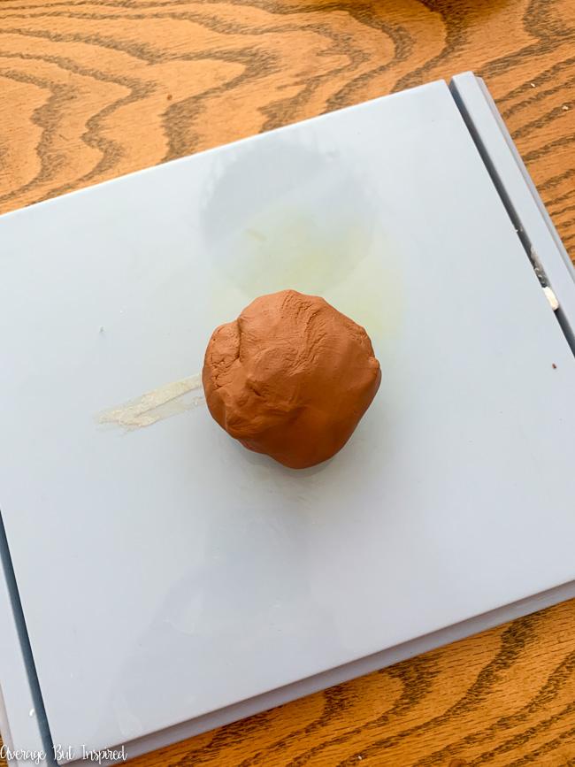 Roll a chunk of terracotta clay into a ball.