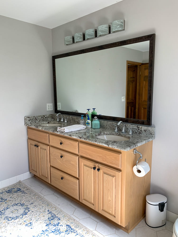 BEFORE - this bathroom has an oak vanity and dated light fixtures. It's getting a modern vintage makeover.