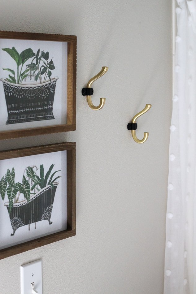 Black and brass towel hooks add a functional and pretty touch to this bathroom.