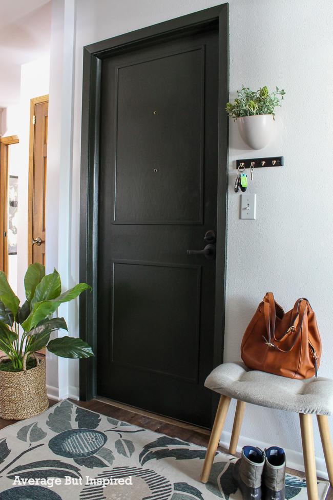 Need no mudroom solutions? Here's one: a wall-mounted key hook holder and small bench help keep this small entryway organized.