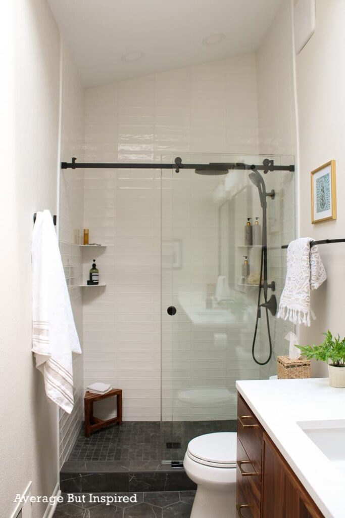 A tall shower with angled ceilings.  The homeowner used stacked elongated subway tile to capture a MCM feel.