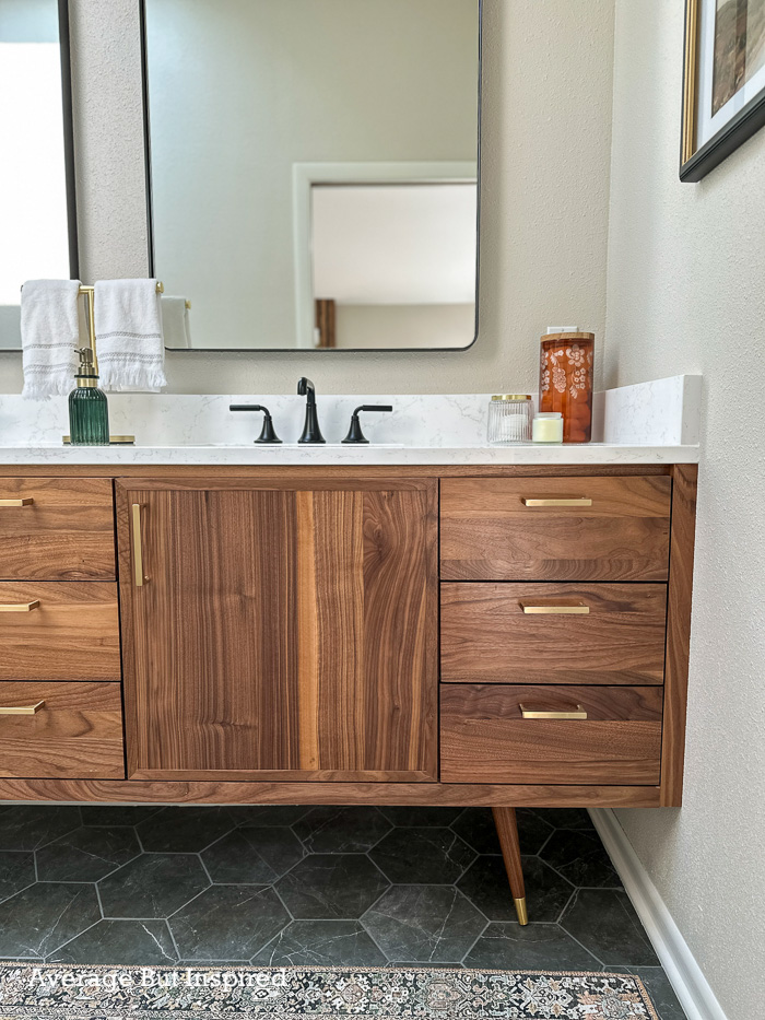 This custom walnut vanity with furniture legs is perfect for this narrow master bathroom.  The renovation style is MCM inspired.