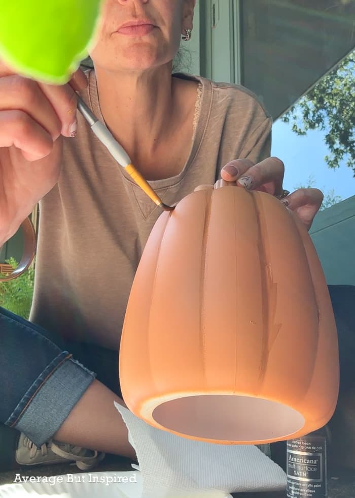 Add detail to plastic pumpkins with brown craft paint