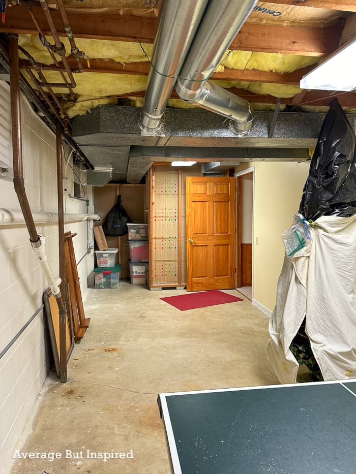 BEFORE: an unfinished basement with exposed stud walls and concrete flooring was converted to a basement home gym.