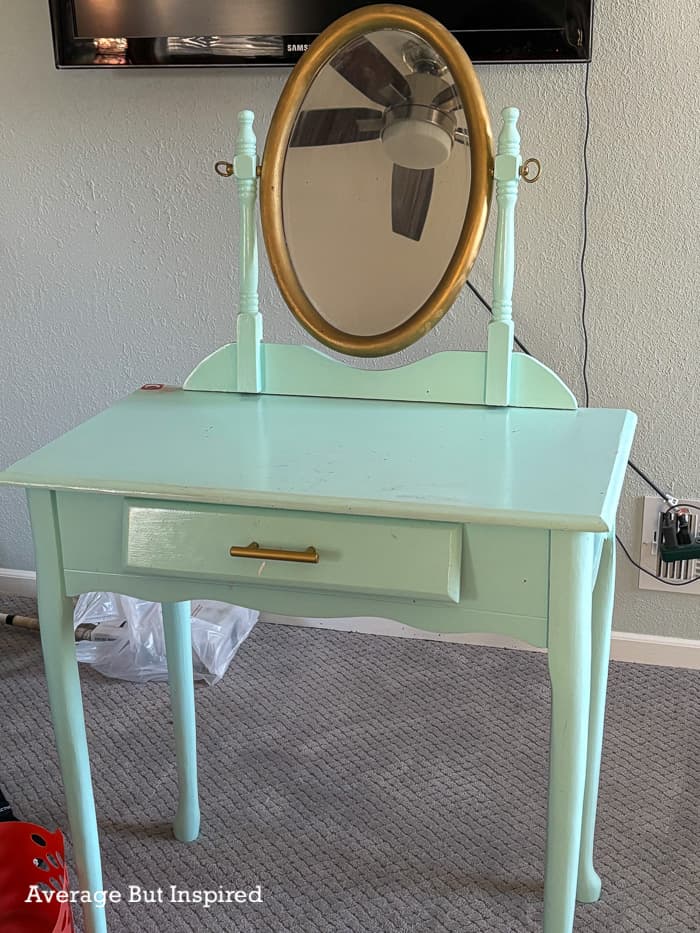 BEFORE: a mint green painted vanity table was given to Bre to refinish.