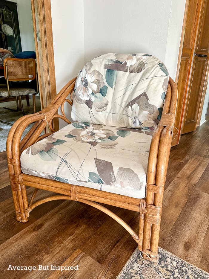 BEFORE: a 1980's style cane chair with floral fabric upholstery was in need of a refresh. Painting the fabric cushions was all it took.